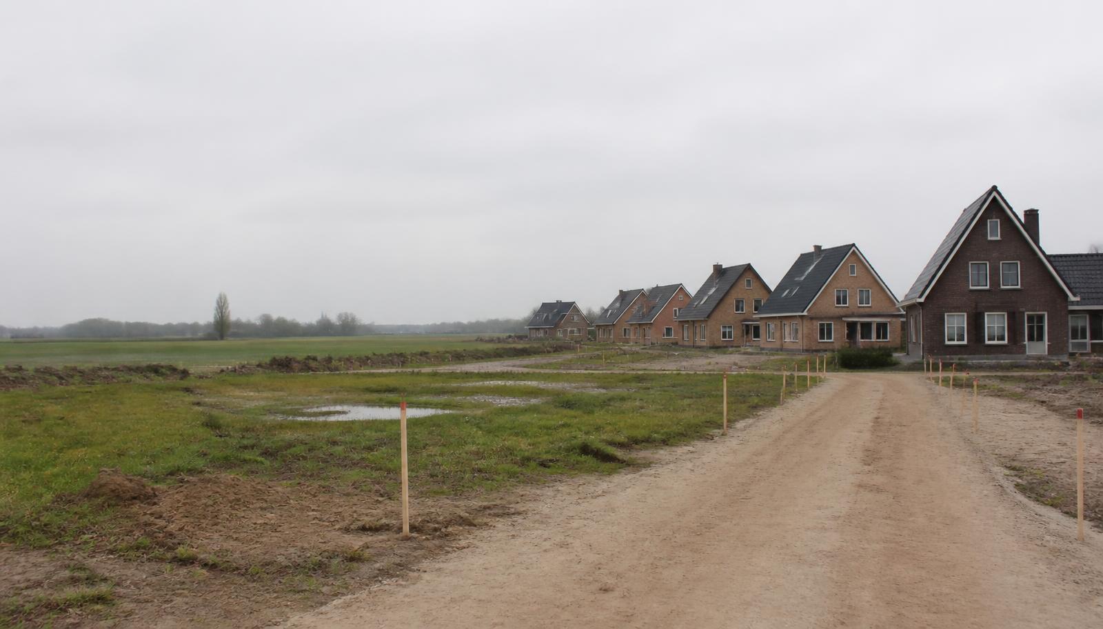Kleinschalige woningbouw aan de rand van een dorp met bouwrijpe kavels en piketpaaltjes